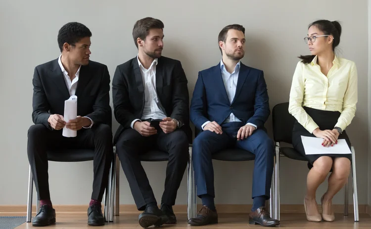 Diverse male applicants looking at female rival among men waiting for at job interview, professional career inequality, employment sexism prejudice, unfair gender discrimination at work