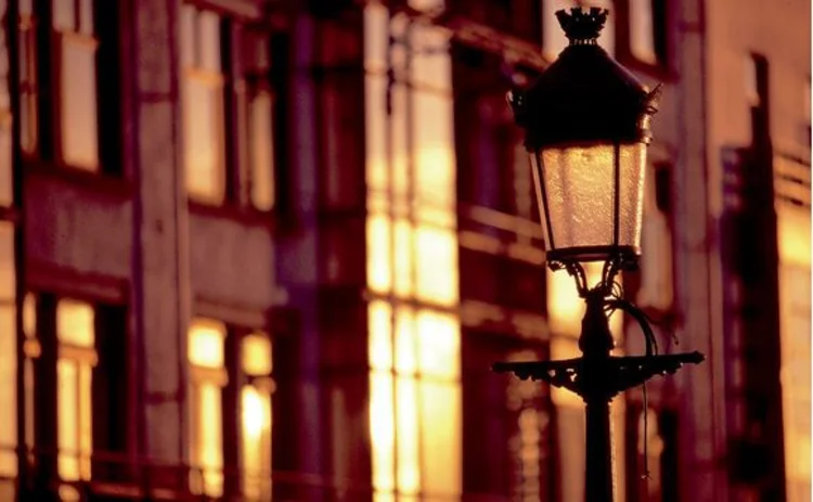 vintage-lamp-post-at-dawn-against-street-of-modern-buildings-closeup