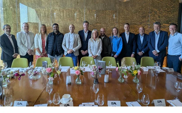 Age/Dual roundtable attendees stand at a table (no names given)