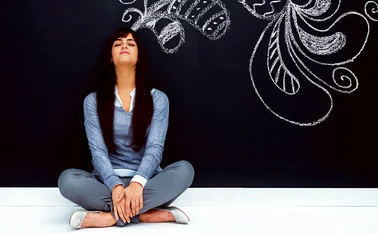 Wellbeing_woman sitting against blackboard and design_for CMS