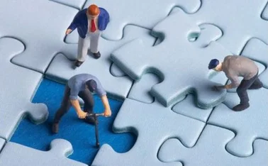 team-of-toy-figures-putting-a-final-jigsaw-piece-into-place