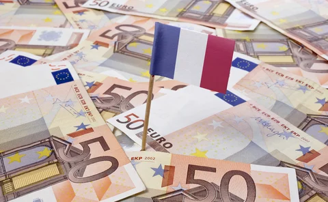 A pile of euro notes with a French flag planted in the middle