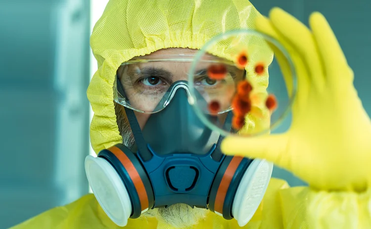 Man in hazmat suit with a petri dish