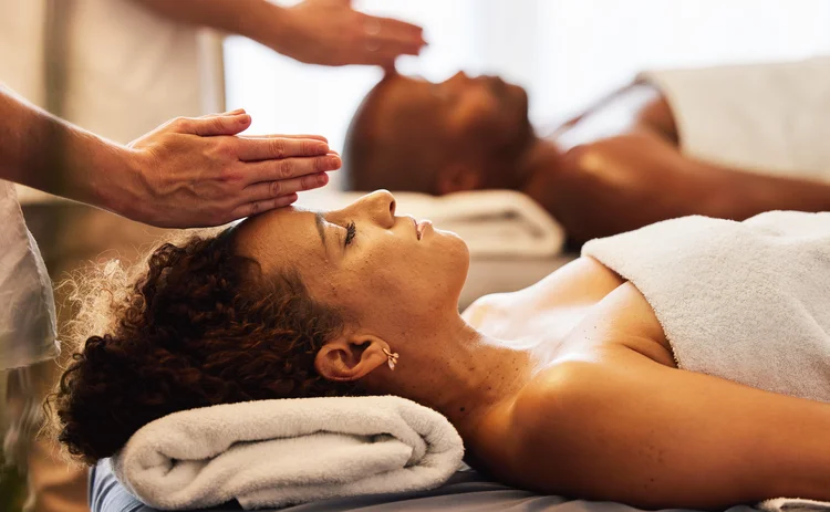 Black couple, head massage and luxury spa to relax in a room for health, wellness and physical therapy. Man and woman on table for skincare, body care and hospitality while on a vacation