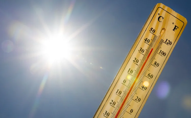 Mercury thermometer marking 39 degrees Celsius 100 Fahrenheit in a sunny day. Summer heat shown on mercury thermometer against the blue sky. Sunlight with sun flares.