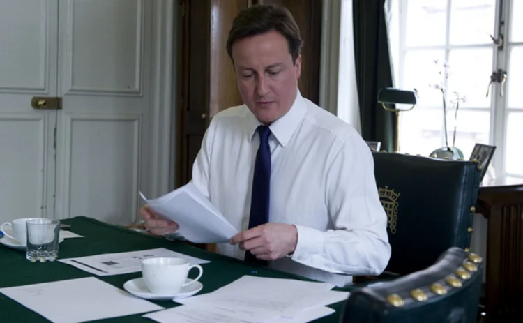 Prime minister David Cameron reading at his desk
