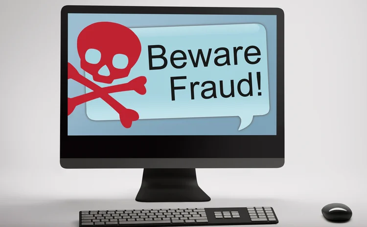 A desktop monitor with 'Beware Fraud' on the screen
