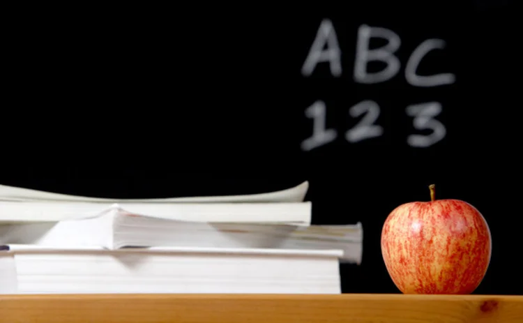 Blackboard and desk with an apple and books on it