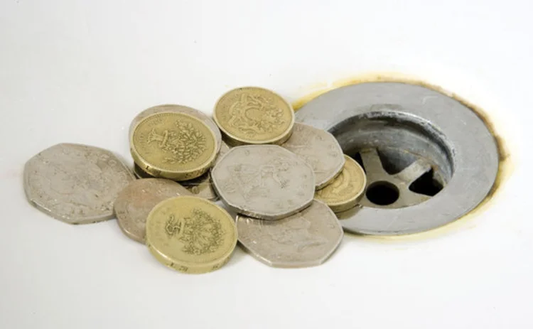 Concept image of UK coins falling down a plug hole