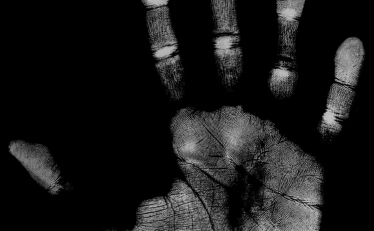 Hand print on a black background showing fingerprints and palm lines