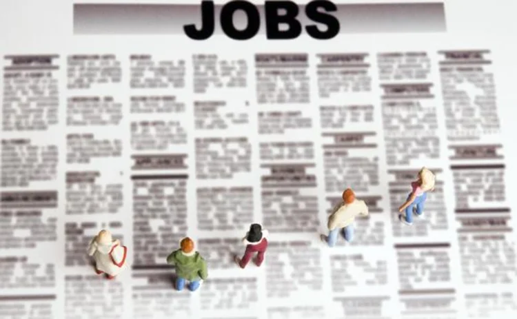 Figurines standing on the jobs paper representing career choice