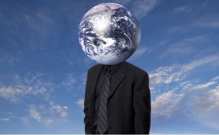 Businessman with globe for head standing in a desert