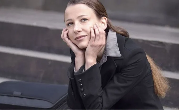 Young businesswoman on step gazing skyward