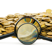 A pile of coins with two magnifying glasses